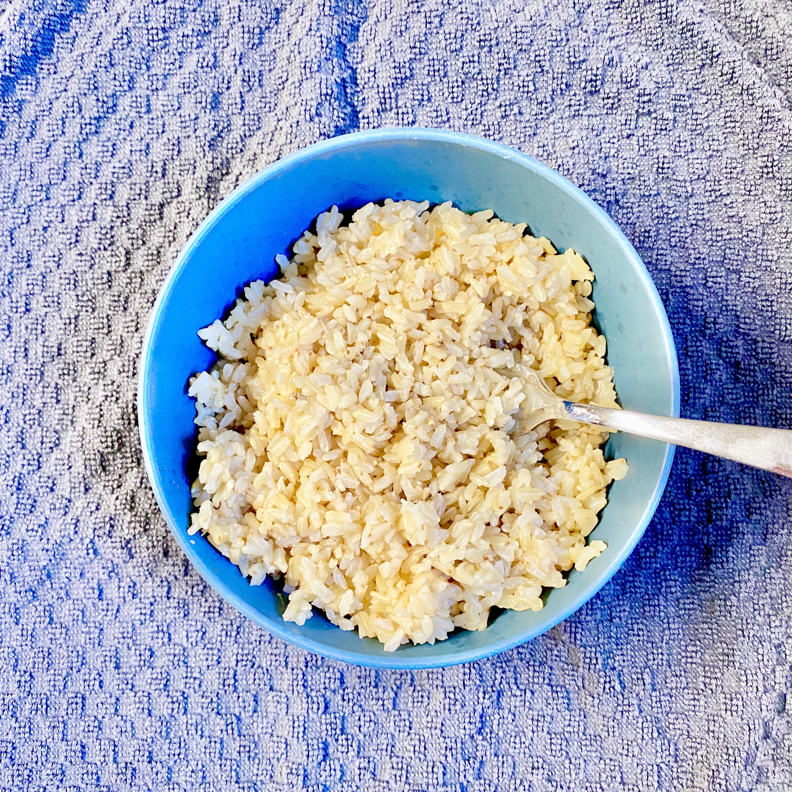  brown rice in a bowl with a fork