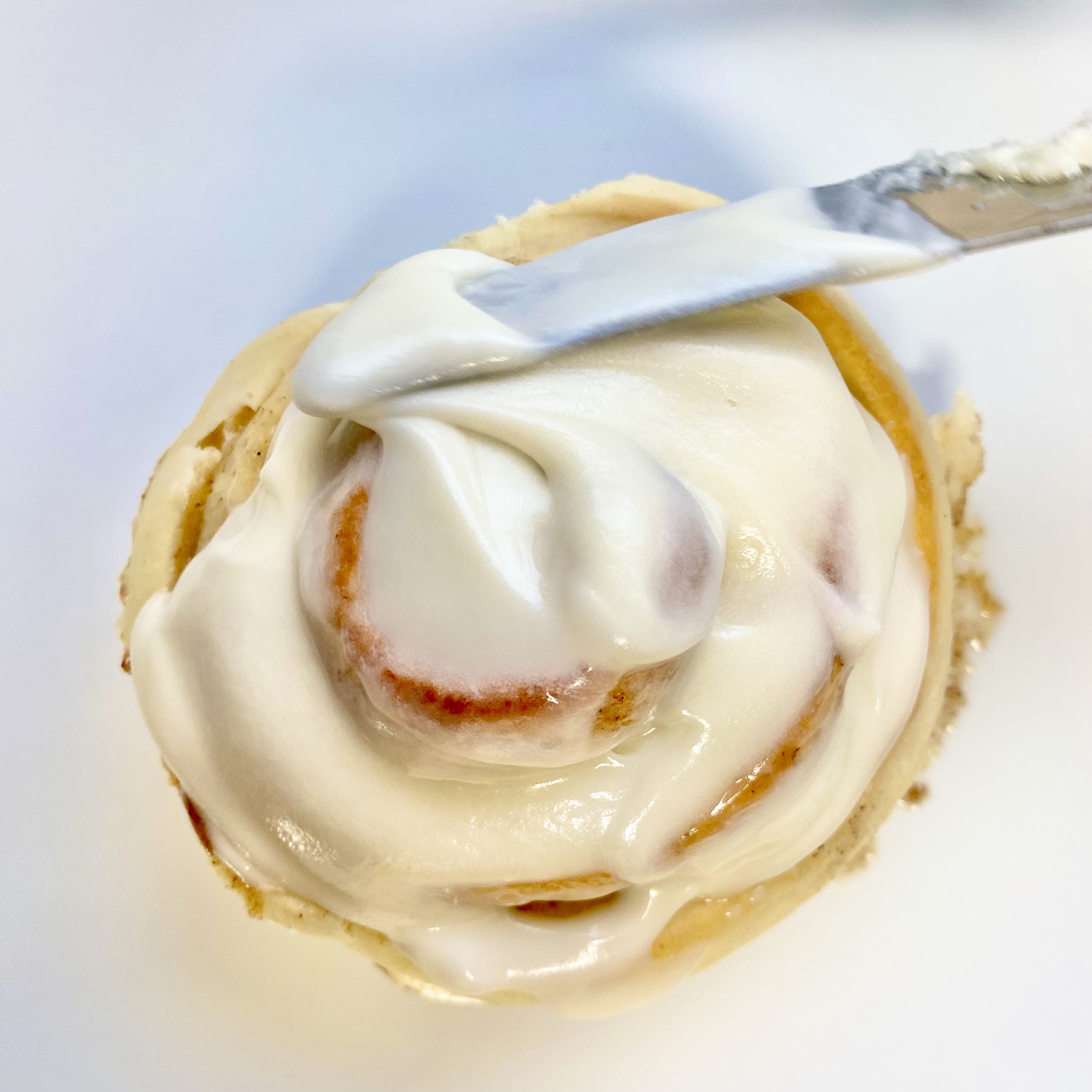 Warm cinnamon roll with frosting dripping down