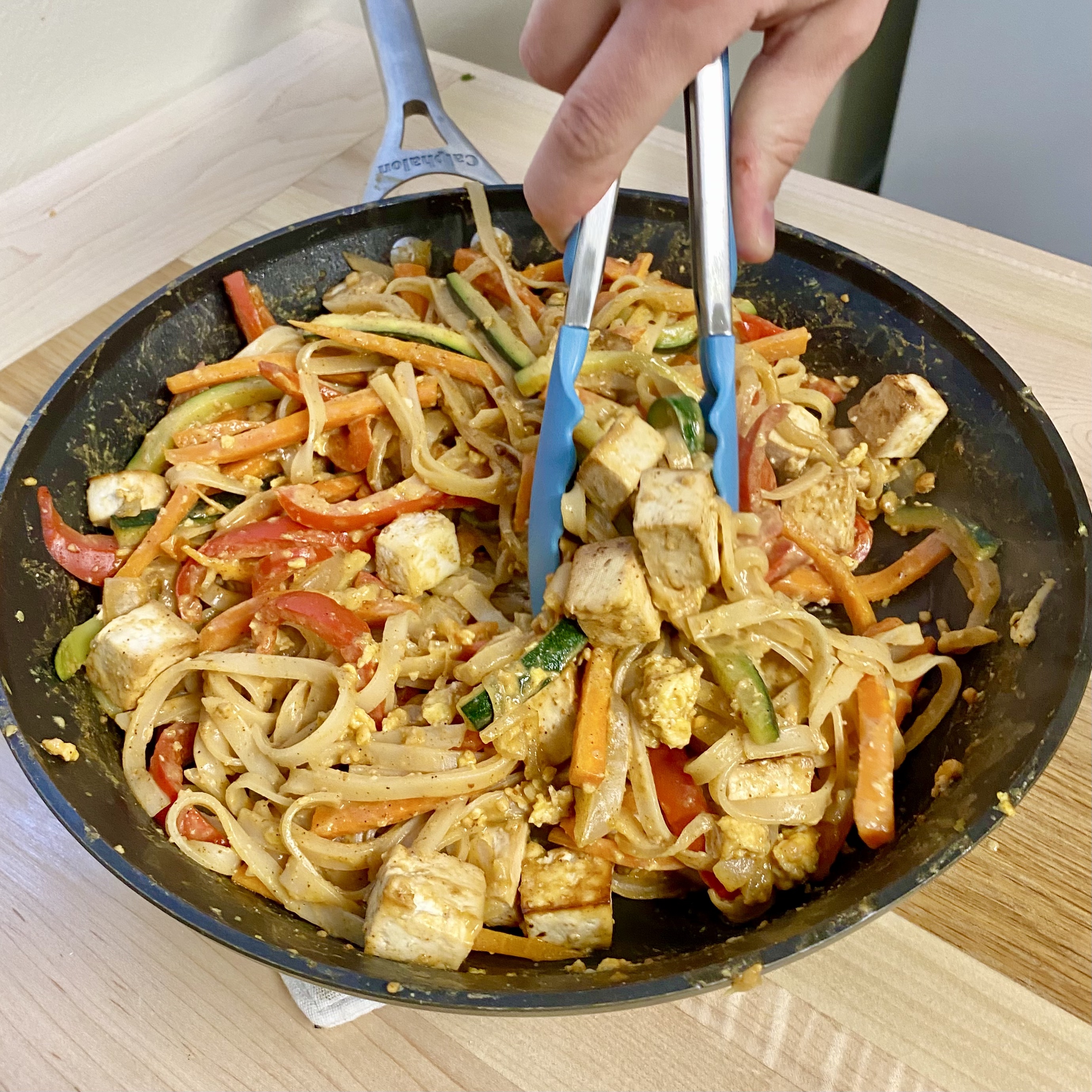 tofu pad Thai topped with broccoli sprouts