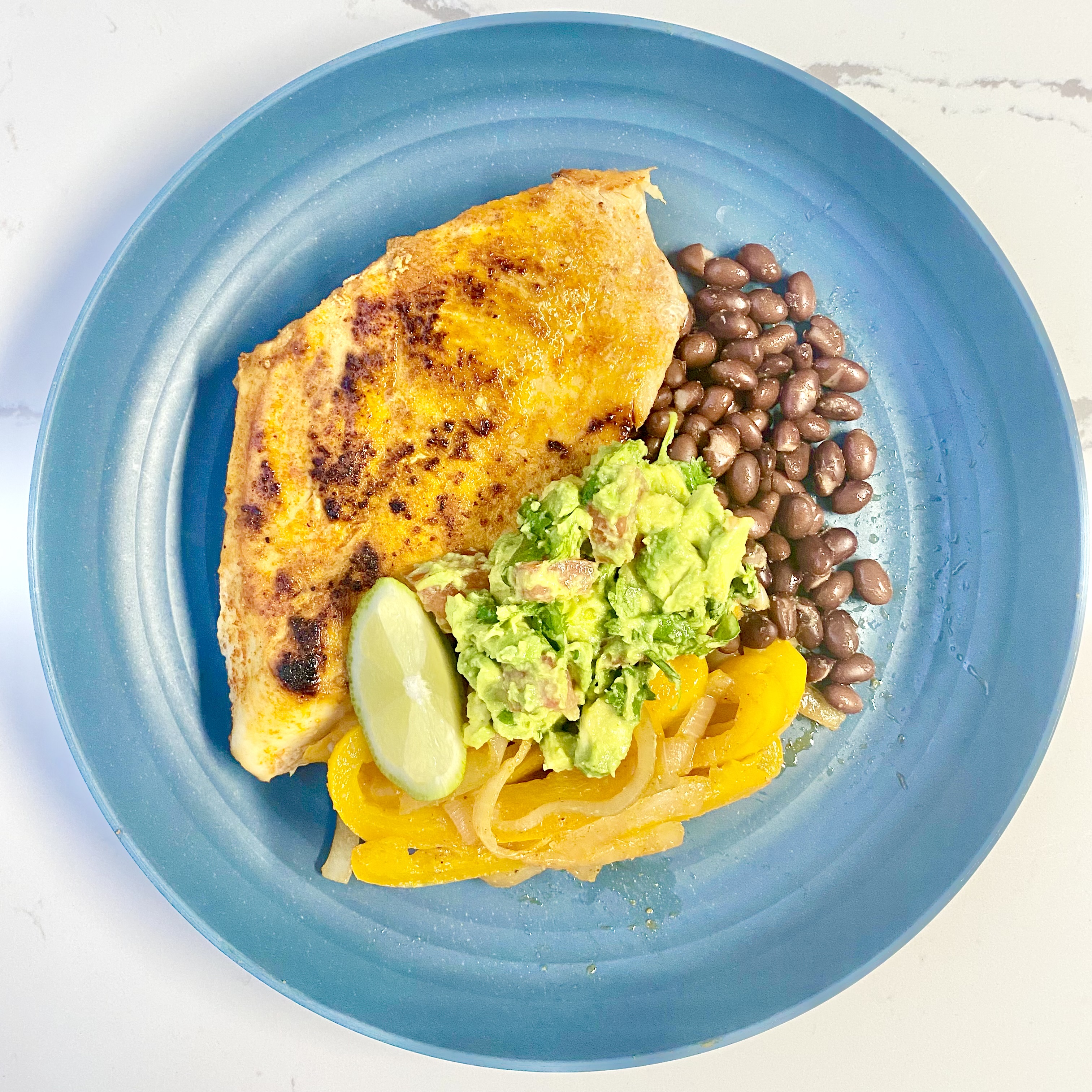 Chicken, beans, guacamole on a plate