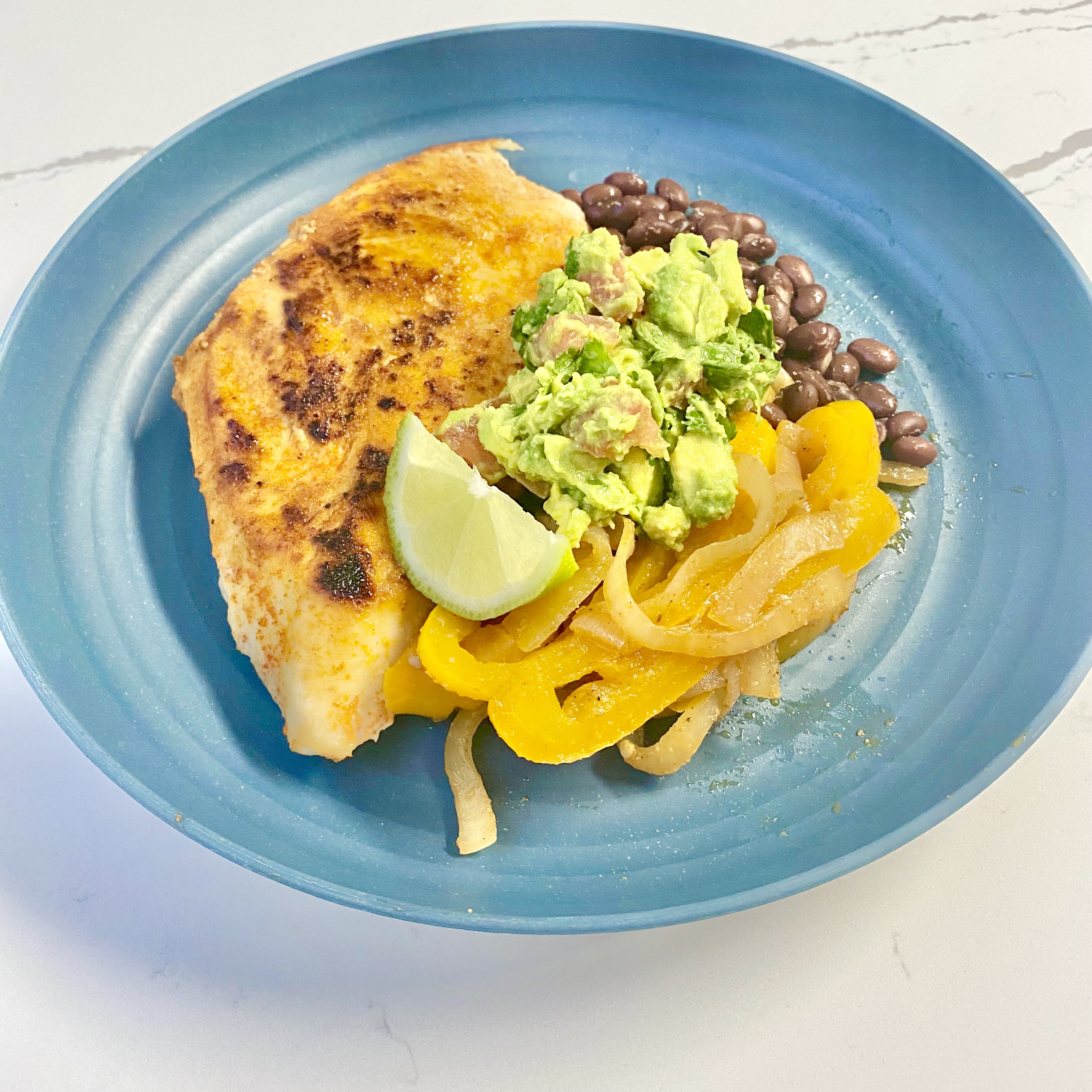 Chicken, beans, guacamole on a plate