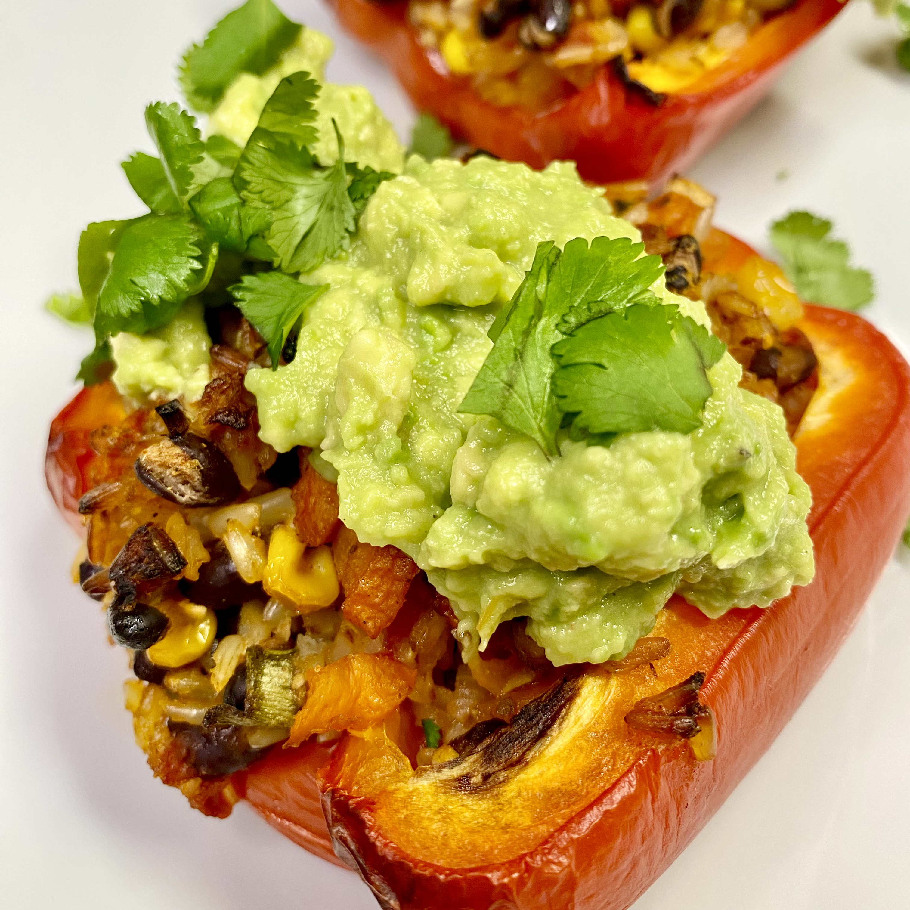 Two stuffed bell peppers with guacamole